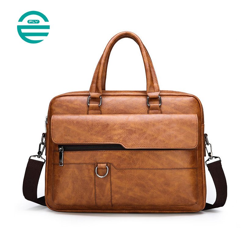 A leather briefcase with a shiny surface and a brass clasp is placed on a wooden floor. The briefcase is slightly open, revealing a zipper and intricate stitching details.